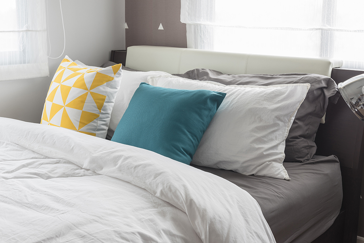 colorful pillows on- white bed in modern bedroom